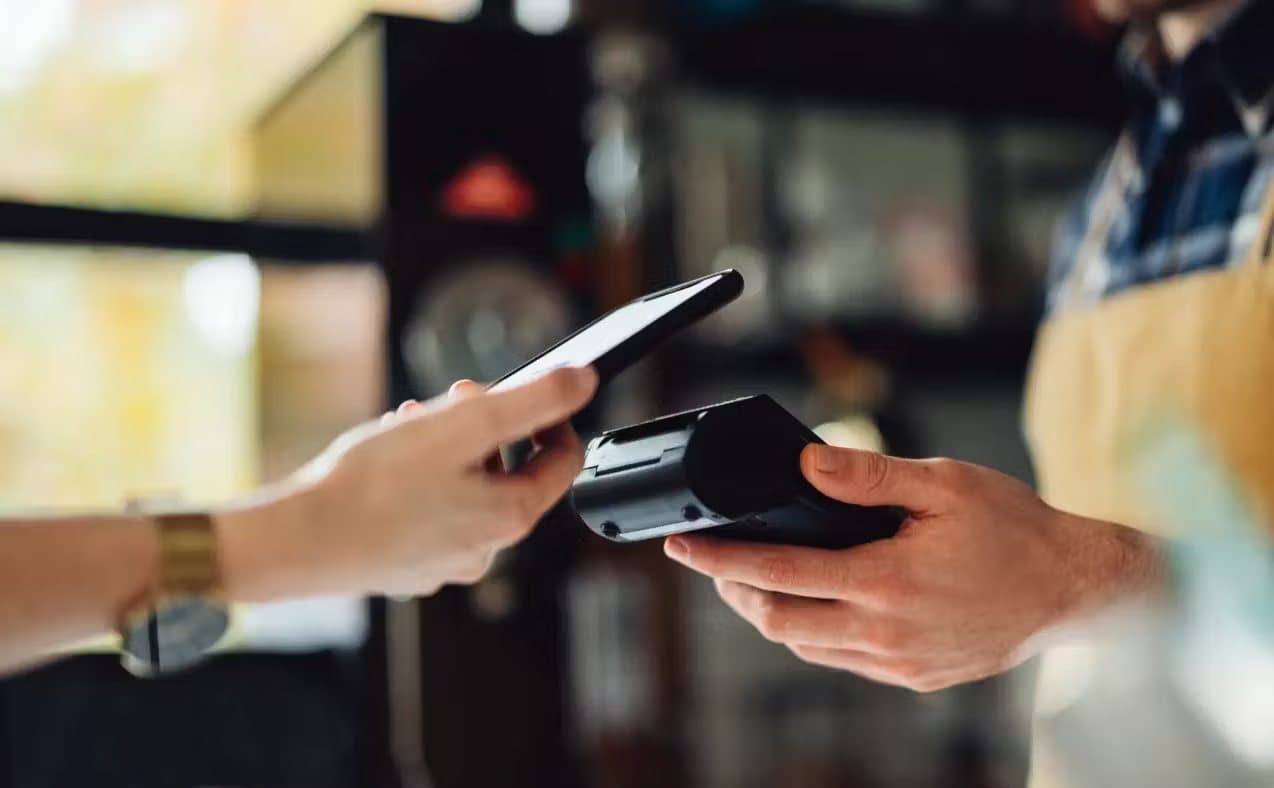 A server taking a contactless payment on a handheld terminal