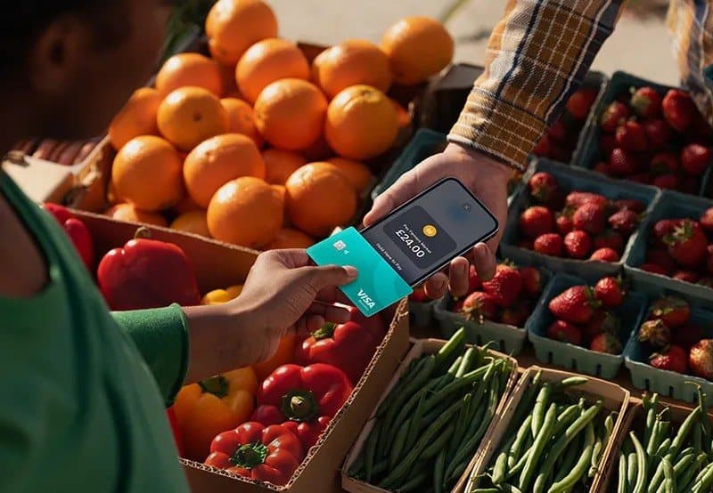 A market vendor accepting a contactless card payment from a customer