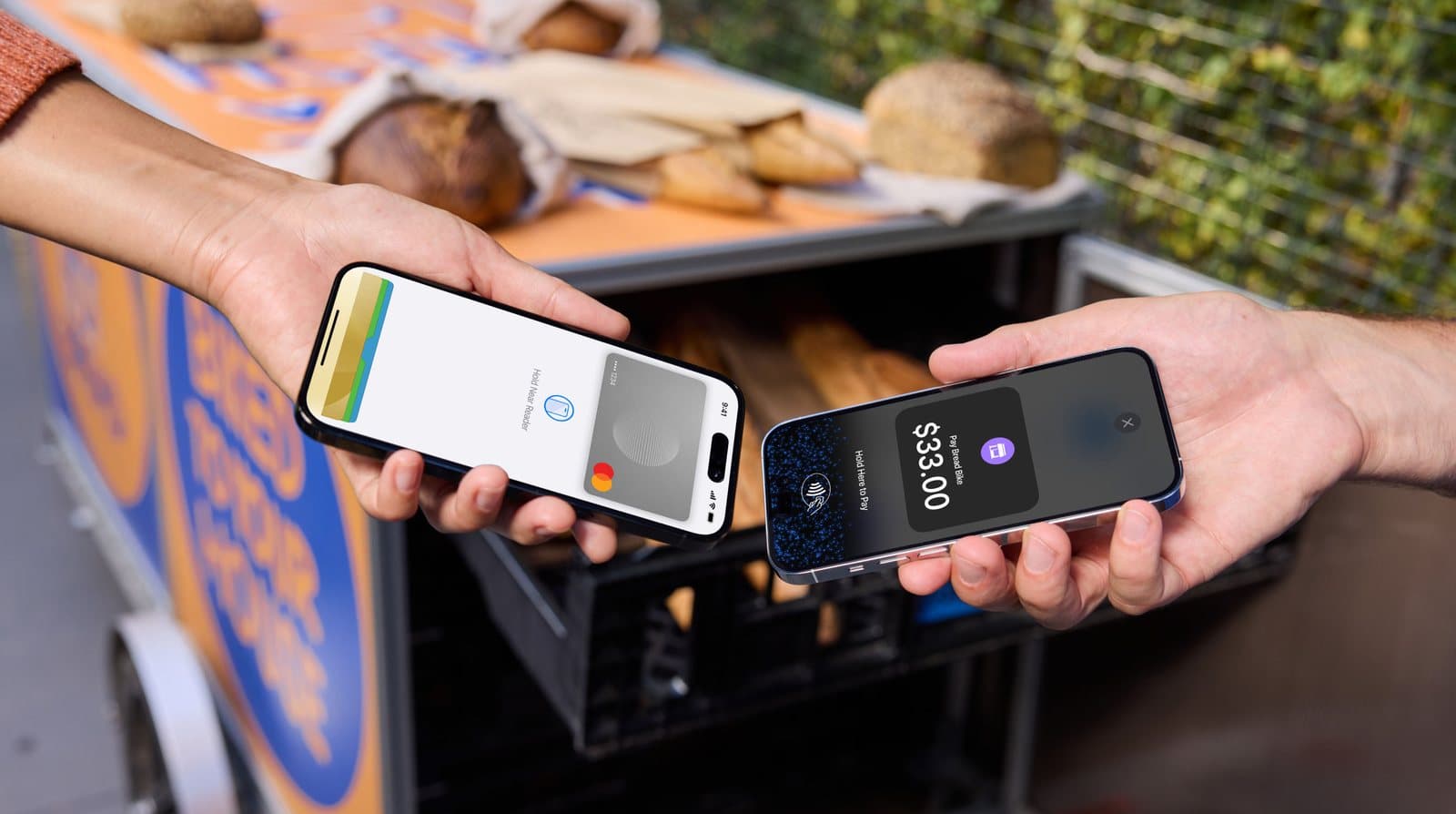A food-cart vendor accepting a tap-to-phone payment from a customer’s phone